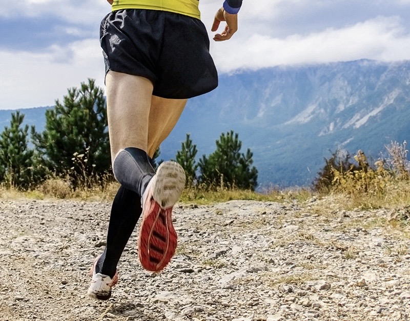 athlete runner run mountain trail marathon in background blue sky
